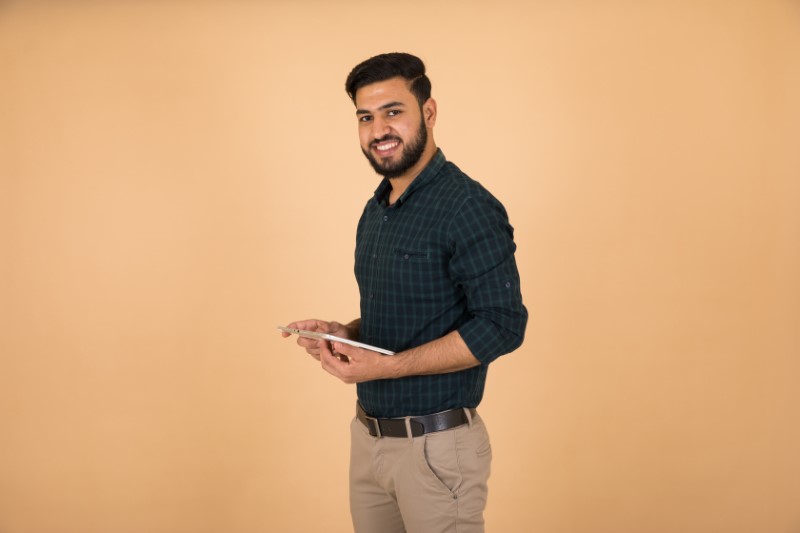 attractive muslim guy holds his tablet