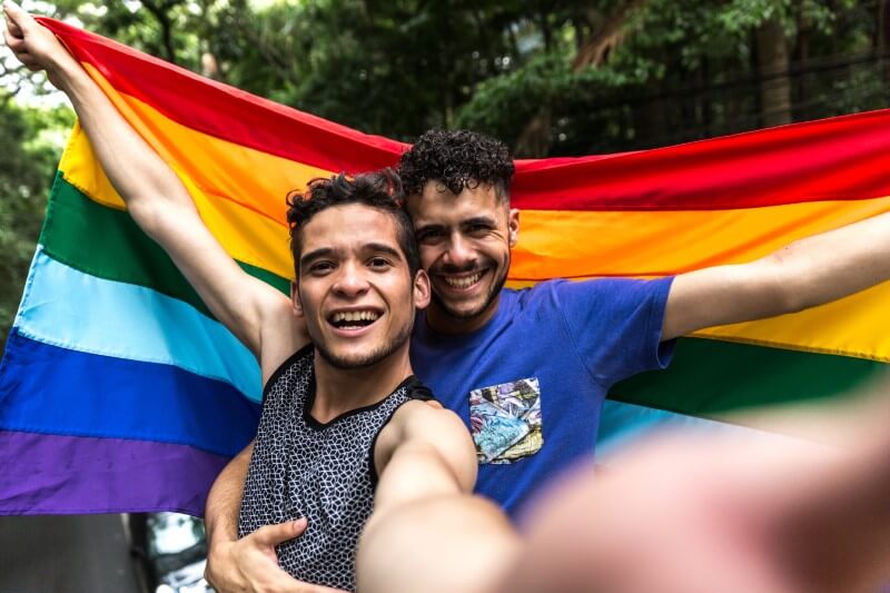 selfie of two men with a gay pride flag